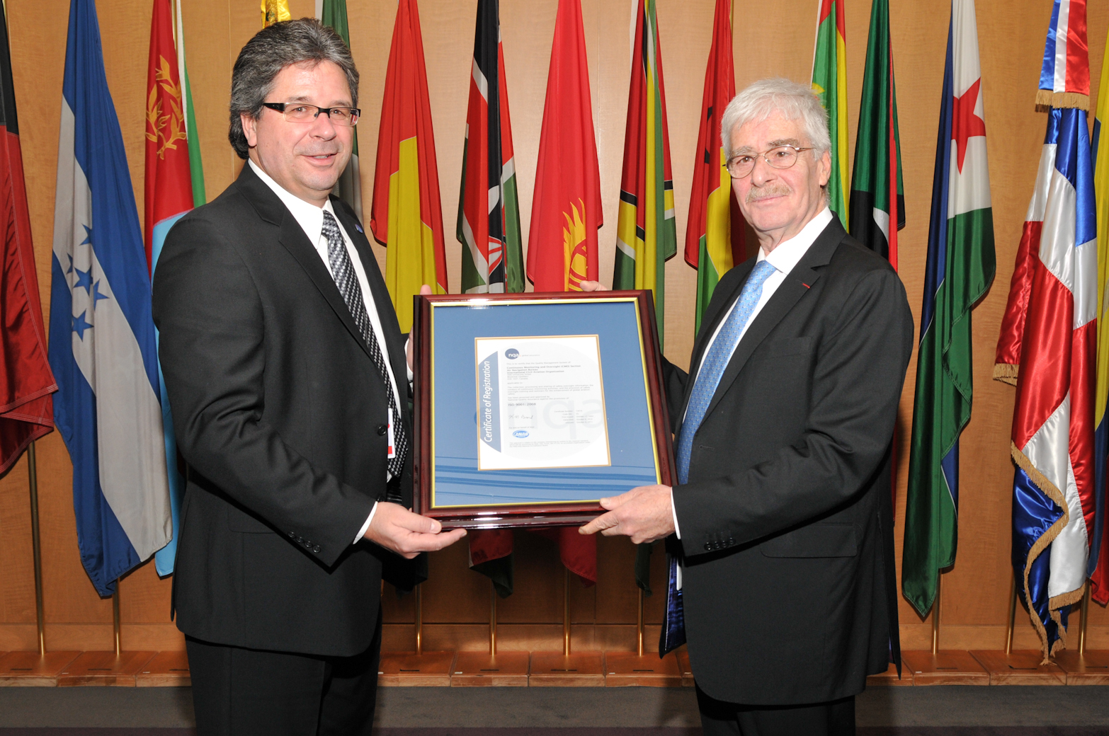 ICAO Secretary General Raymond Benjamin (right) receives the ISO 9001:2008 certificate from Mario David, Sales & Operations Manager for National Quality Assurance (NQA) – Canada
