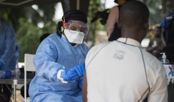  A member of the ring vaccination team vaccinates a man in Bosolo village.